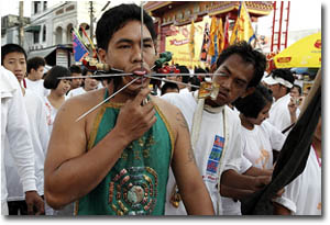 Hombre con agujas en la boca en el festival vegetariano de Phuket