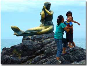 niños junto a la estatua de la sirena en Songkhla